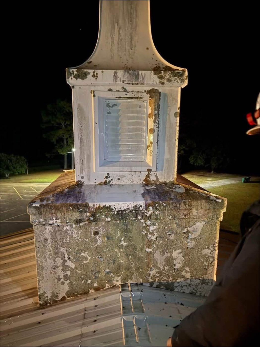 Church steeple before soft washing, covered in lichen and algae